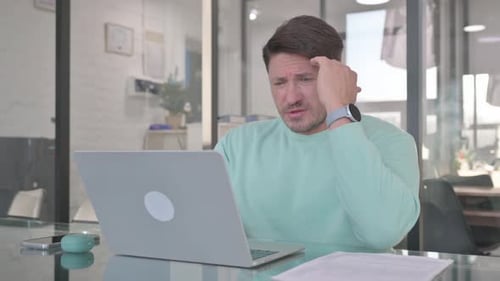 Stressed Man Working on Laptop in Office