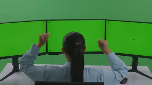 Happy Asian Woman Celebrating While Working With Mock Up Multiple Computer Monitor In Green Screen