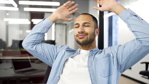 Smiling Man Relaxing in Modern Office Environment