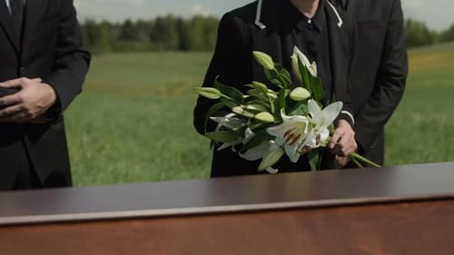 Mourners by Coffin in Grassy Rural Field