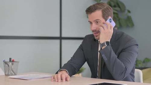 Man Talking on Phone at Office Desk