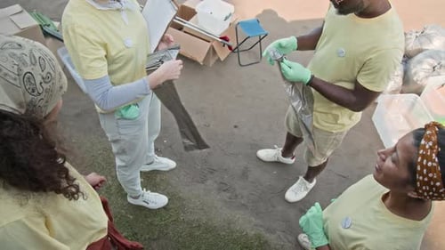 Activistas ecológicos multiétnicos se llevan bolsas de basura de plástico antes de la limpieza