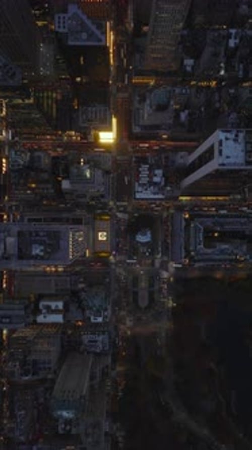 Aerial Views Capture Traffic Flowing Through Vibrant Streets of New York City at Night in Slow