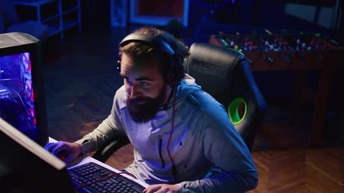 Man Wearing Headphones Gaming at Computer