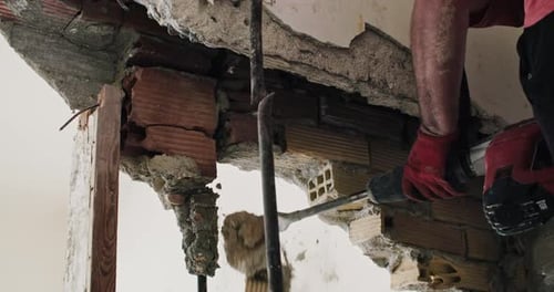 Closeup of Male Hands Dismantling Wall with Jackhammer Showcasing Construction