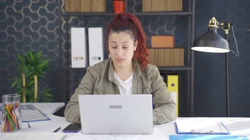 Focused Woman Working on Laptop in Office