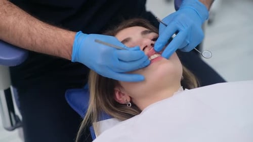 Professional Dental Checkup of Female Patient in Modern Dentistry Clinic Doctor Looking at Teeth