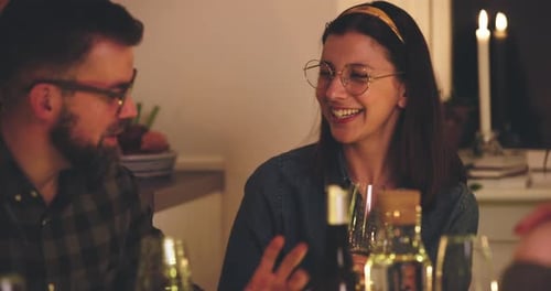 Friends Chatting and Drinking at a Warm Dinner