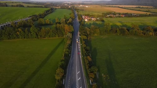 Aerial view of a multi-way road with an intersection and passing cars.