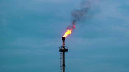 Oil Refinery Fire Gas Torch Against Cloudy Sky - Low Angle Shot