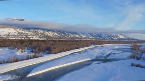 Aerial view of snow covered pine trees mountains and the snake river in Wyoming