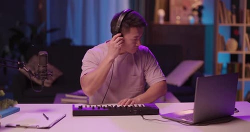 Young adult playing music on electronic keyboard