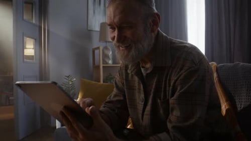 Senior Man Uses Tablet Device Indoors