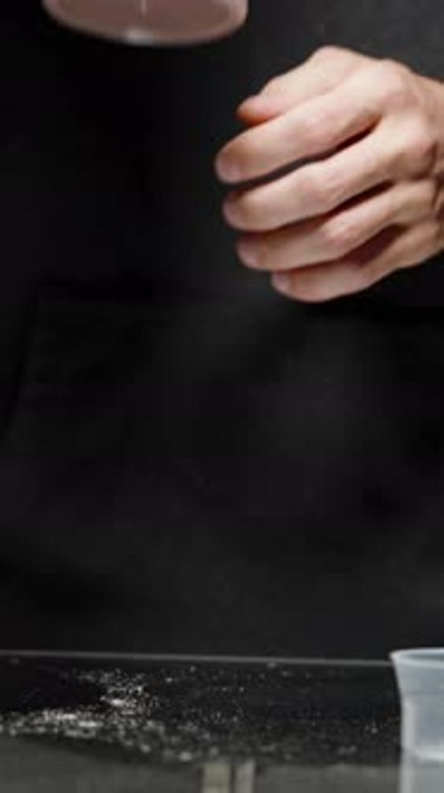 Vertical video. A Man Prepared A Chocolate Shake From Protein Powder. Numerous Cans Of Supplements