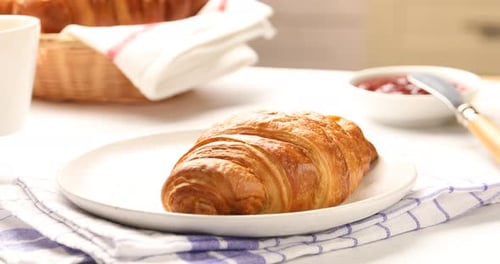 Golden Croissant and Coffee on Marble Countertop