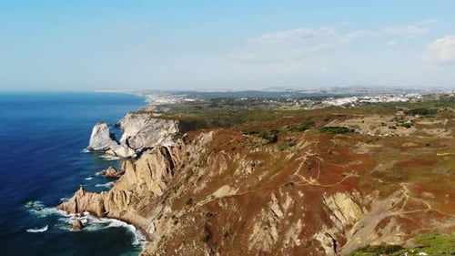 Sobrevolando la costa rocosa Exploración del paisaje de la costa bordeada de acantilados con exuberantes áreas cubiertas de hierba visibles