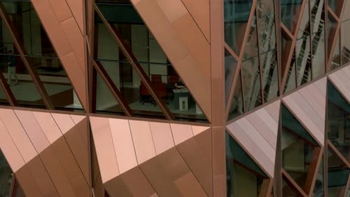 Aerial shot of the modern glass skyscraper exterior with sunshine and reflection