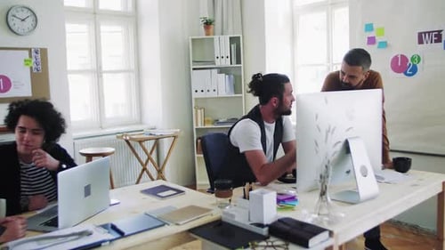 Group of Young Businesspeople with Computer Working Together in a Modern Office