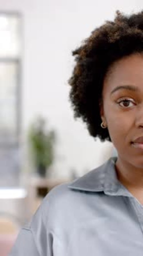 Vertical video of half portrait of african american casual businesswoman in office, slow motion