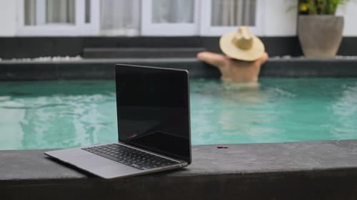 Young Freelancer Relaxing at Swimming Pool at Daytime