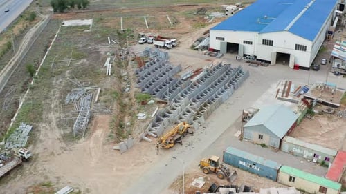 Aerial Drone View of Industrial Factory Yard with Heavy Equipment and Metal Structures Manufacturing
