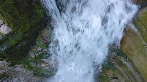 Waterfall on Mountain River with White Foamy Water Falling Down From Rocky Formation in Summer