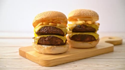 Delicious Burgers on Wooden Cutting Board