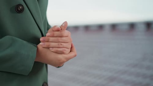 Woman Clasping Hands in an Urban Setting