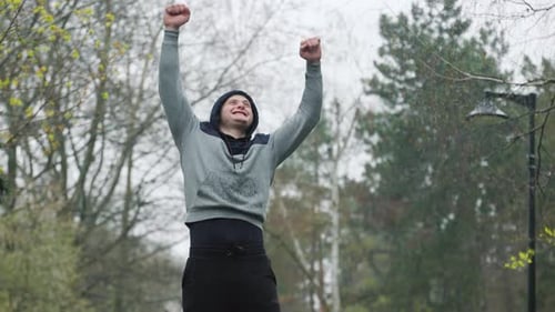 Man Celebrating Success in the Rain Outdoors
