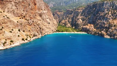 Calm blue waterscape of the Mediterranean Sea surrounded by stunning mountains.