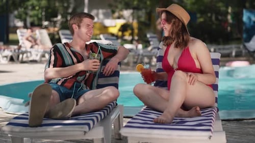 A Couple on Vacation are Enjoying a Relaxing Time By the Pool with Refreshing Drinks