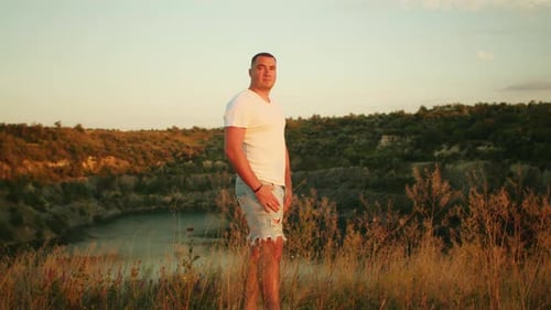 Man Standing in Field at Golden Hour Concept of Tranquility and Reflection in Nature Design for