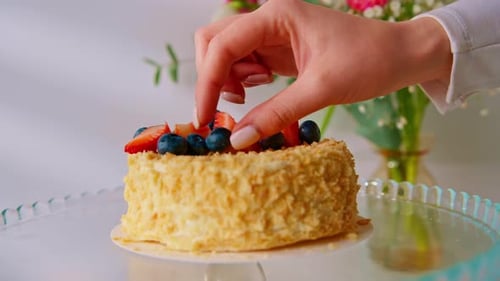 Freshly prepared delicious Napoleon cake from puff pastry hand decorates the dessert with fresh