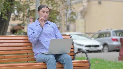 Woman on Park Bench With Laptop Looking Stressed