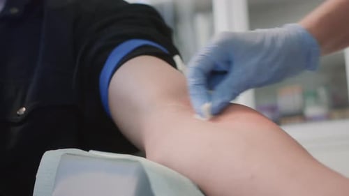 Nurse Disinfects Hand of Male Patient Thoroughly Preparing for Medical Procedure