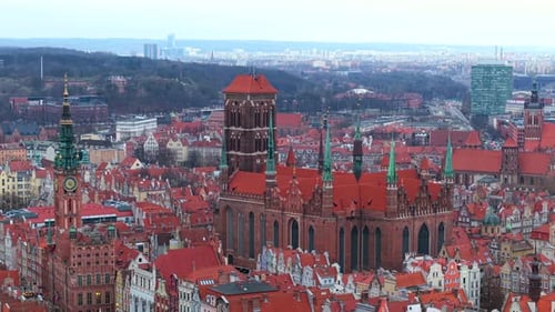 Aerial drone shot of Gdansk Old Town focusing on St. Mary’s Church and shipyard afar