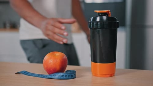 Apple, Shaker, and Tape Measure for Healthy Diet