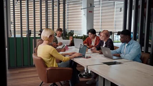 Purposeful Diverse Team of Managers Analyzing Sales Growth Diagrams Working Together in the Office