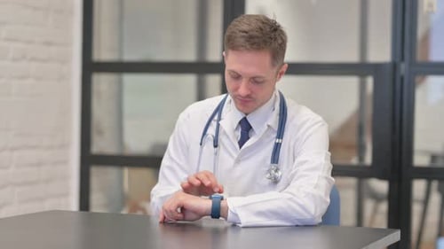 Male Doctor Using Smartwatch in Clinic