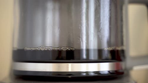 Brewed filter coffee of electric glass coffee pot close up 4K