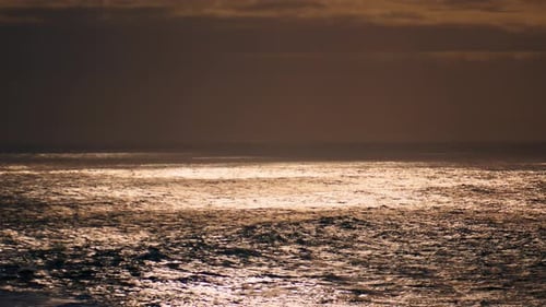 Meeresoberfläche, die Sonnenlicht am bewölkten Himmel reflektiert. Friedliche endlose Meereslandschaft. Ruhig