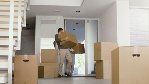 Couple moving into new home with cardboard boxes