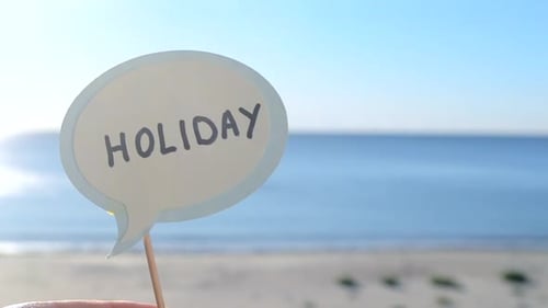 Stick with Paper Speech Bubble with Words Holiday on Background Sea Sky Sandy
