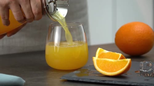 Pouring Refreshing Orange Juice into Glass