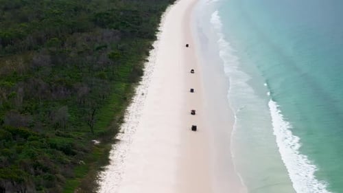 Aerial view of jeep on beach and ocean, Australia.