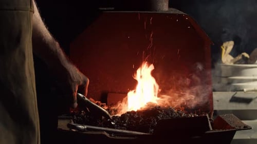 Blacksmith Forging Sparks Fly in Dark Workshop