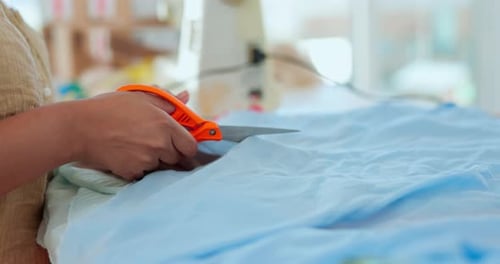 Woman Cutting Blue Fabric with Scissors Close Up
