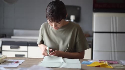 Young Woman Cutting Fabric at Table