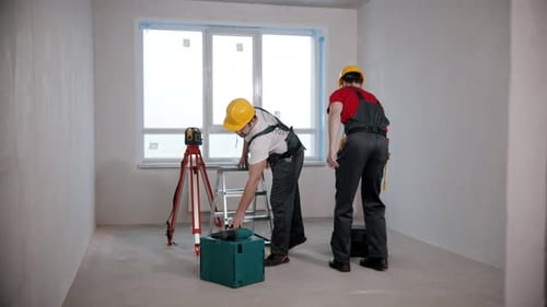 Construction Workers Discussing Project in Unfinished Room