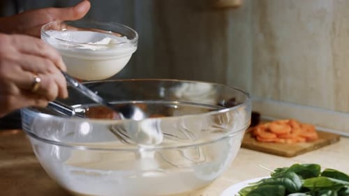 Mixing Fresh Eggs Flour and Milk with Steel Hand Mixer in a Glass Bowl